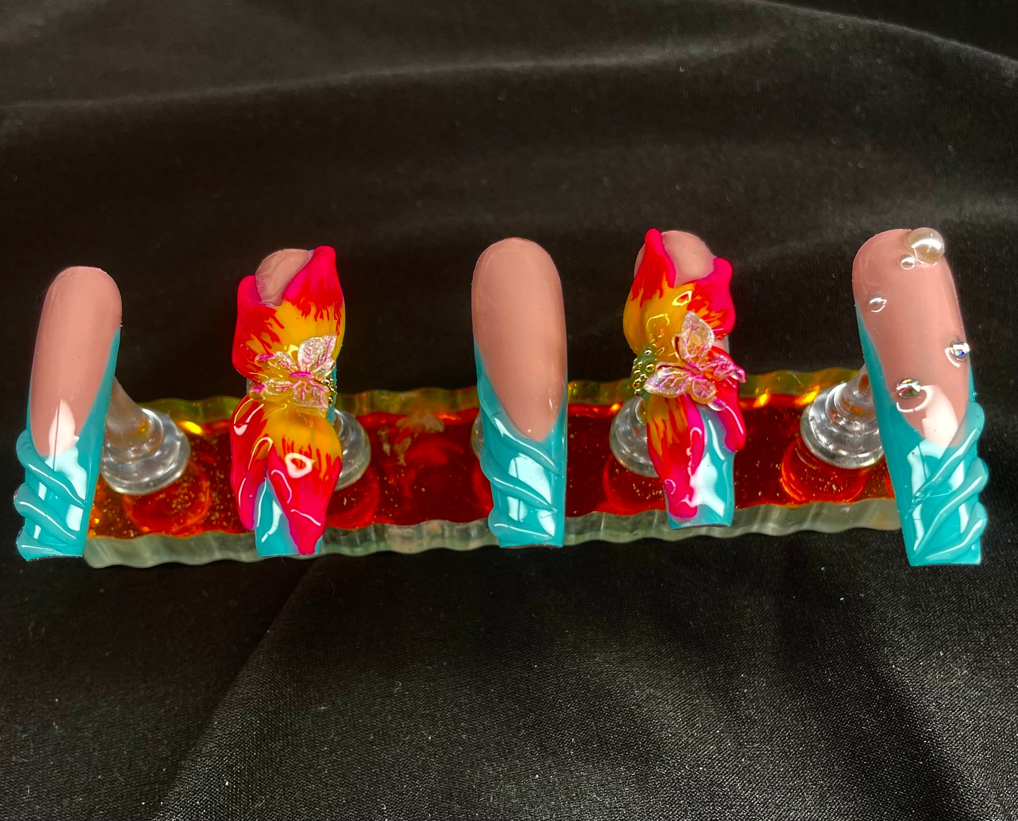 Set of false nails with colorful designs on a black background